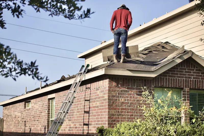Professional roofer working on a residential roof in Georges